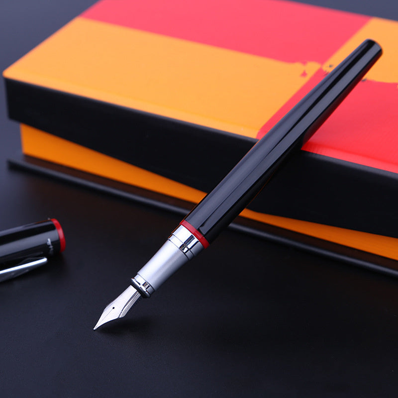 Fountain pen with a red accent on a black surface, with a colorful notebook in the background.