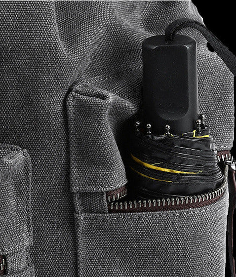 Gray backpack with a black umbrella inside a pocket on a white background